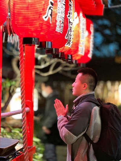 a man standing in front of a red lantern