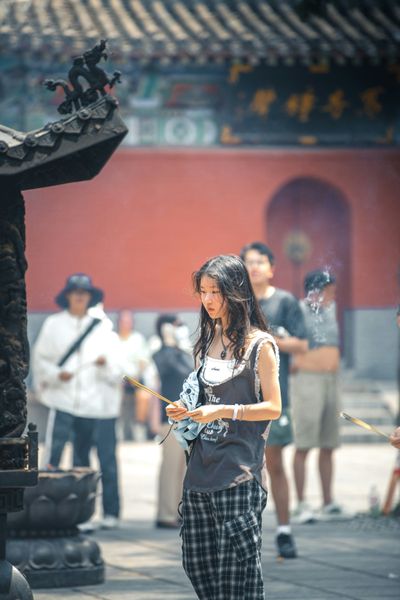 a woman prays at an asian temple