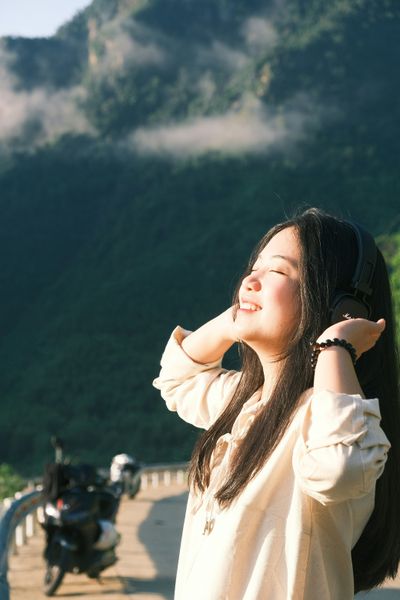 a woman standing next to a motorcycle on a road